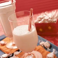 two glasses of milkshakes on a tray with cookies and marshmallows