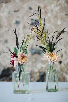 two vases with flowers are sitting on a table