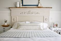 a white bed sitting in a bedroom next to a dresser with drawers and a mirror on top of it