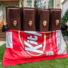 some people are holding up giant chocolate bags in front of a house with their faces on them