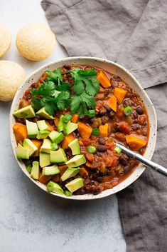 a bowl filled with beans, avocado and tortilla chips on top of a table