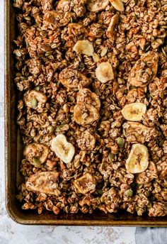 granola with bananas and nuts in a baking pan