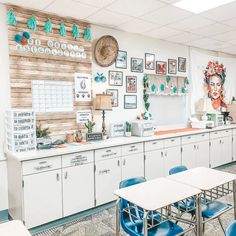 an empty classroom with blue chairs and pictures on the wall