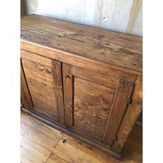 an old wooden cabinet sitting on top of a hard wood floor next to a wall