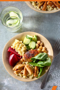 there is a plate of food on the table next to a glass of water and a fork