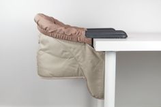 a pair of gloves hanging from the back of a chair next to a white table