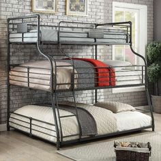 a metal bunk bed sitting in a bedroom next to a table with a lamp on it