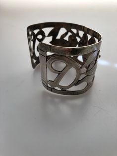 I purchased this handmade sterling silver cuff bracelet out of an estate of a seamstress back in my hometown about 25 years ago. The seamstress was active in the 1940s,1950s and 1960s. I had no idea she also dabbled in making sterling jewelry but I bought this and about 20 other pieces from her two sisters after she had passed away. The bracelet features a lovely openwork cut out design of a flower in the center flanked by two lovebirds and her initials D T ...one on each end. I am sure this is Vintage Stamped 925 Cuff Bracelet For Wedding, Unique Handmade Sterling Silver Bracelet For Anniversary, Unique Handmade Sterling Silver Anniversary Bracelet, Vintage Sterling Silver Cuff Bracelet For Anniversary, Handmade Vintage Sterling Silver Bangle, Unique Cuff Bracelet For Anniversary, Unique Engraved Cuff Bracelet For Anniversary, Unique Silver Cuff Bracelet For Anniversary, Unique Bangle Cuff Bracelet For Anniversary