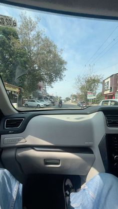 the interior of a car with someone's feet on the dashboard