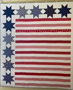 an american flag quilt hanging on the wall