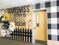 an office decorated with black and white checkered paper flowers, the words happiness is blooming within this room