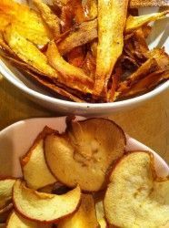 two bowls filled with potato wedges on top of a wooden table next to another bowl full of fries