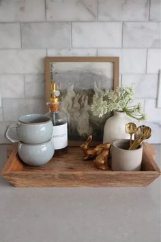 a tray with some cups and vases on it