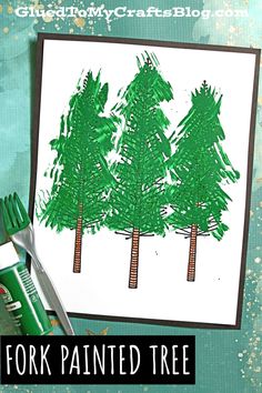 a green and white card with trees drawn on it next to a pair of scissors