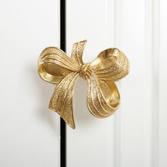 a close up of a door handle with a gold bow on it's side