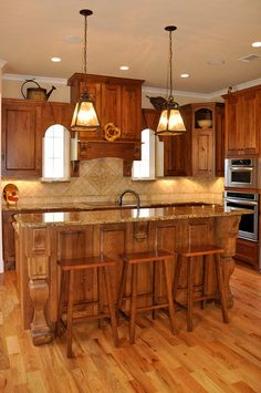 a large kitchen with wooden cabinets and an island in the middle is shown, along with two stools