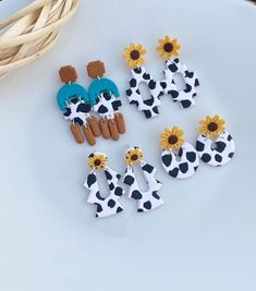 six pairs of cow earrings with sunflowers on them