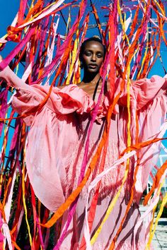 a woman in a pink dress surrounded by streamers