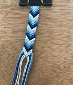 a close up of a blue and white rope on a wooden table with a metal hook