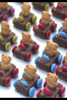 many small teddy bears are sitting on toy cars made out of chocolates and candy