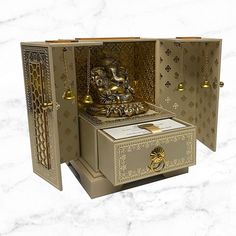 an intricately designed box with a buddha statue in the middle and gold trimmings