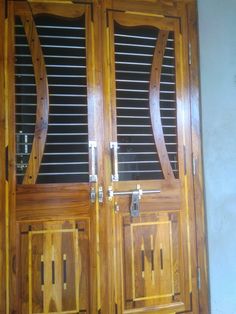 two wooden doors with metal handles and shutters