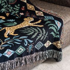 a black blanket with a cheetah on it sitting on top of a couch