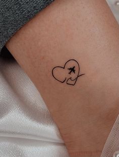 a woman's arm with a small heart tattoo on the left side of her right arm