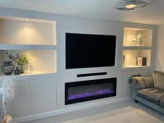 a living room with a couch, television and fireplace