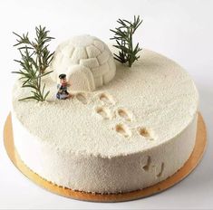 a cake with white frosting and small figurines sitting on top of it