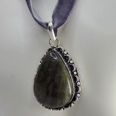 This is a lovely labradorite pendant in white bronze, we send to you on a gray satin ribbon East Village Bangles is the product of love ❤️, a unique collection of vintage jewelry painstakingly restored by Casey in the East Village. Even as we put love, sweat (and sometimes tears!) into restoring these items, it is our policy that you must be thrilled. We stand behind every item and we will take it back if it is not for you. Gray Pendant Jewelry For Gifts, Gray Pendant Jewelry As A Gift, Unique Gray Jewelry As Gift, Unique Gray Jewelry For Gifts, Unique Gray Jewelry For Gift, Gray Pendant Necklace Gift, Antique Silver Teardrop Jewelry As Gifts, Gray Sterling Silver Necklace For Gift, Gray Sterling Silver Necklace Gift