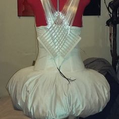 a mannequin with plastic wrapped around it's neck and back, sitting on top of a bed