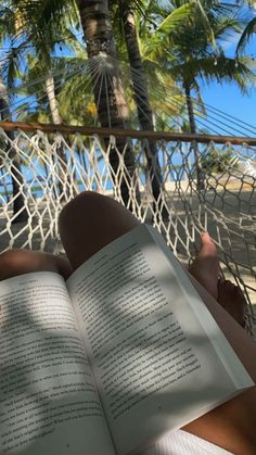 a person laying in a hammock reading a book