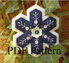 a blue and white snowflake ornament hanging from a leafy tree