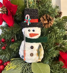 a snowman ornament hanging from a christmas tree