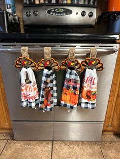 three kitchen towels hanging from the front of an oven