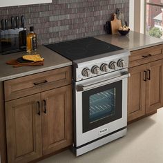 a stove top oven sitting inside of a kitchen next to wooden cabinets and counter tops