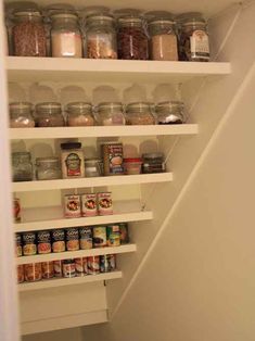 an organized pantry under the stairs in a house