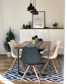 a dining room table with chairs and a rug on the floor