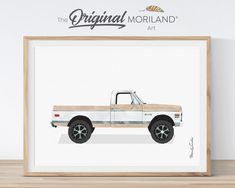 the original morland truck art print is displayed in a wooden frame on a shelf