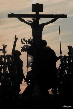 the silhouette of a crucifix is shown against a cloudy sky