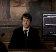 a man sitting at a desk in front of a monitor