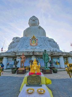 a large buddha statue sitting in front of a building