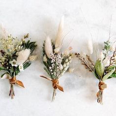 three boutonnieres with dried flowers tied to them