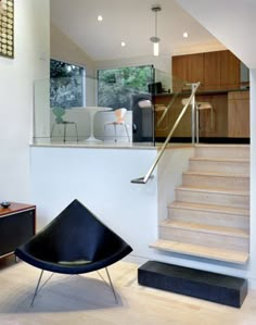 a modern living room with stairs leading up to the second floor and an open kitchen