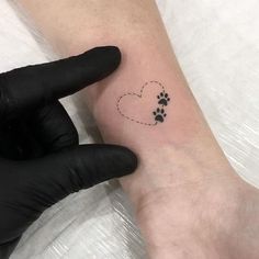 a person with a tattoo on their arm and paw prints in the shape of a heart