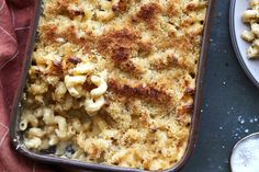 macaroni and cheese in a baking dish on a table next to two plates