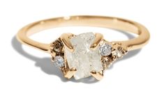 a yellow gold ring with an oval cut diamond surrounded by three smaller round brilliant diamonds