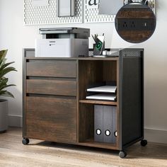 a desk with a printer and other items on it next to a potted plant