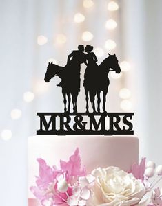 a wedding cake topper that says mr and mrs with two horses on the top